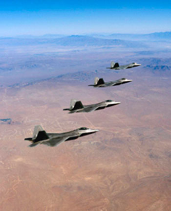 Four F/A-22 Raptors fly over the Mojave Desert during a landmark test mission